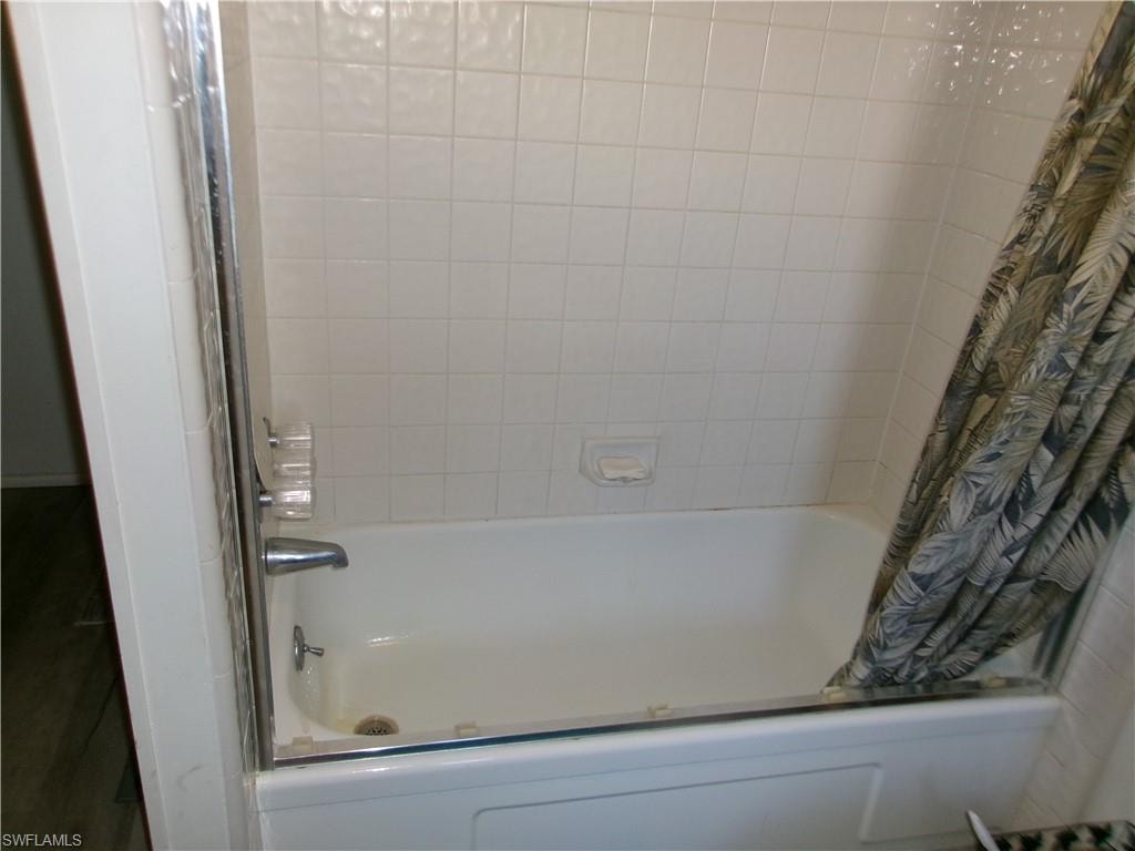 Full bathroom featuring shower / bathtub combination with curtain