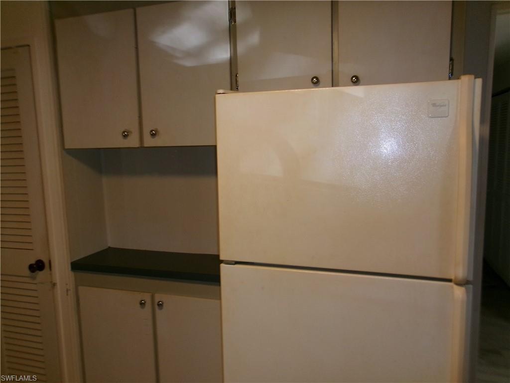 Kitchen featuring freestanding refrigerator and dark countertops