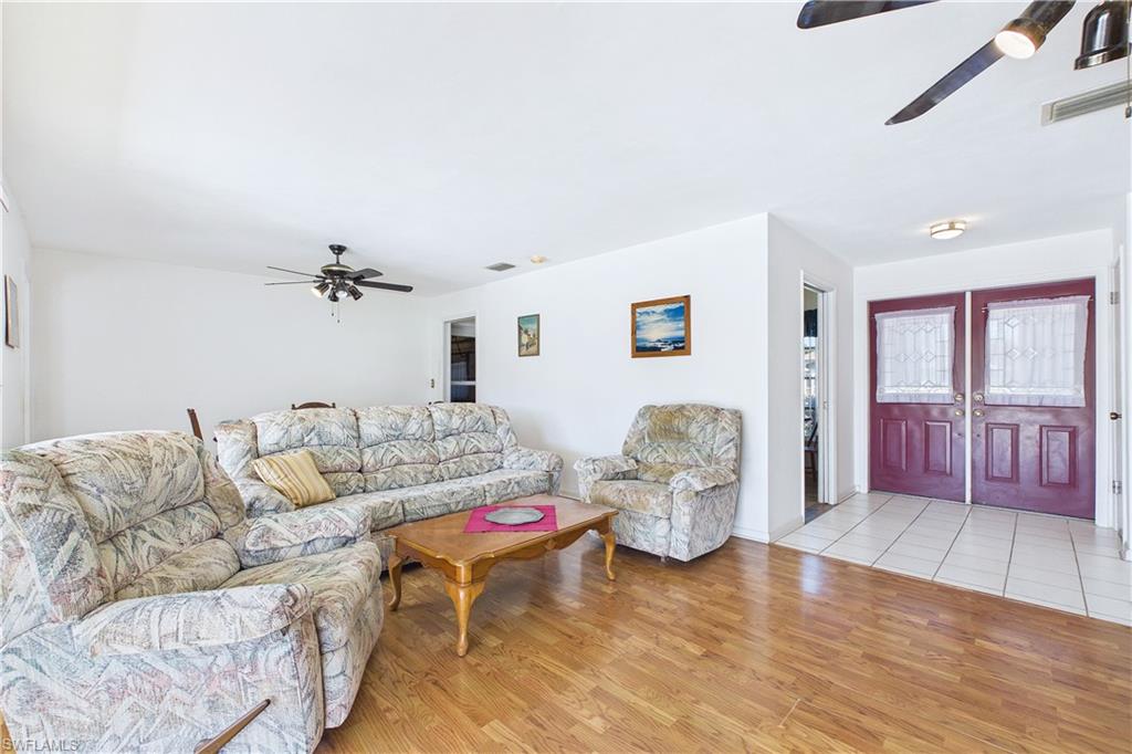 Living area with ceiling fan and light wood-style flooring