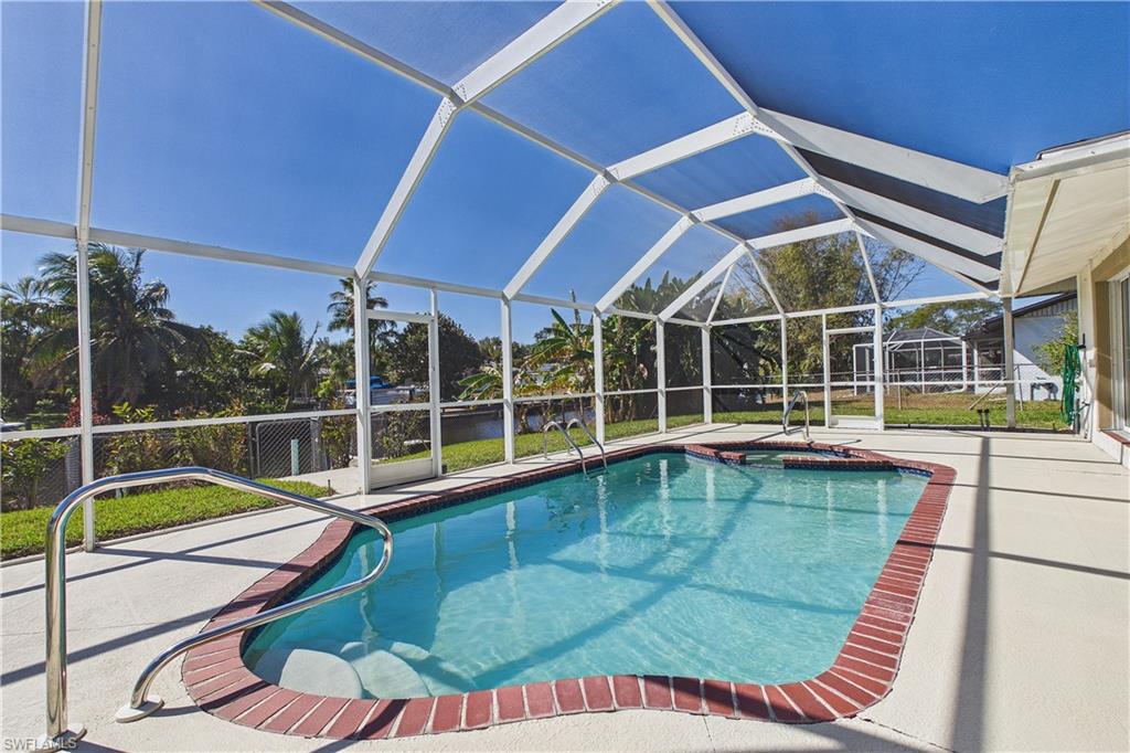Outdoor pool with a lanai, a sunroom, a patio area, and a jacuzzi