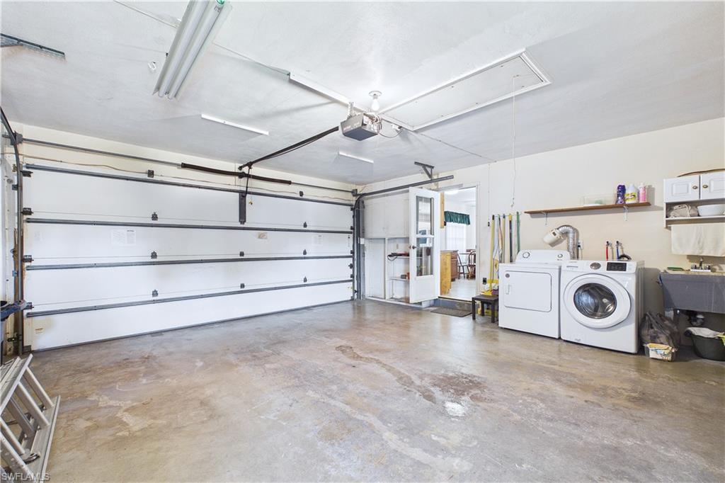Garage featuring washer and clothes dryer and a garage door opener