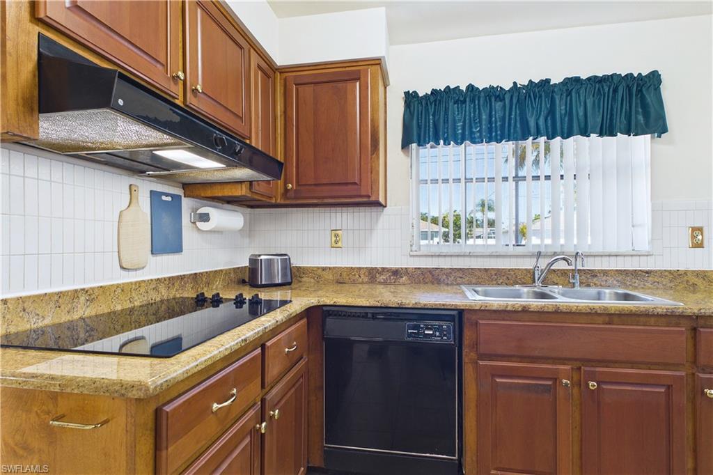 Kitchen featuring black appliances, wood finish cabinetry, and tasteful backsplash