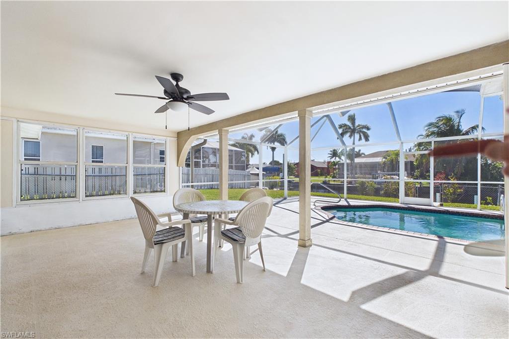 Sunroom / solarium featuring a patio, a ceiling fan, a swimming pool, and outdoor dining area