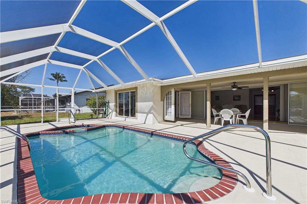 Integrated pool / hot tub featuring a lanai, a sunroom, a patio area, and outdoor dining area