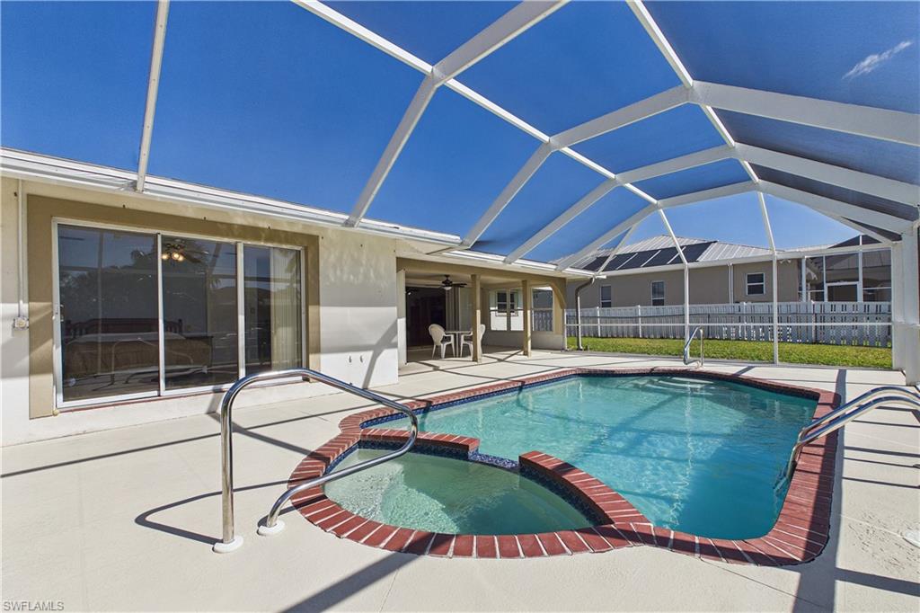 Integrated pool / hot tub with a sunroom, a patio, and glass enclosure