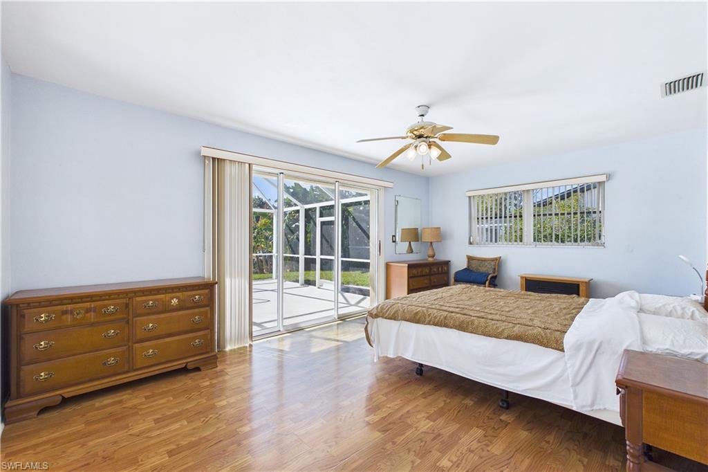 Bedroom with access to exterior, wood finished floors, and ceiling fan