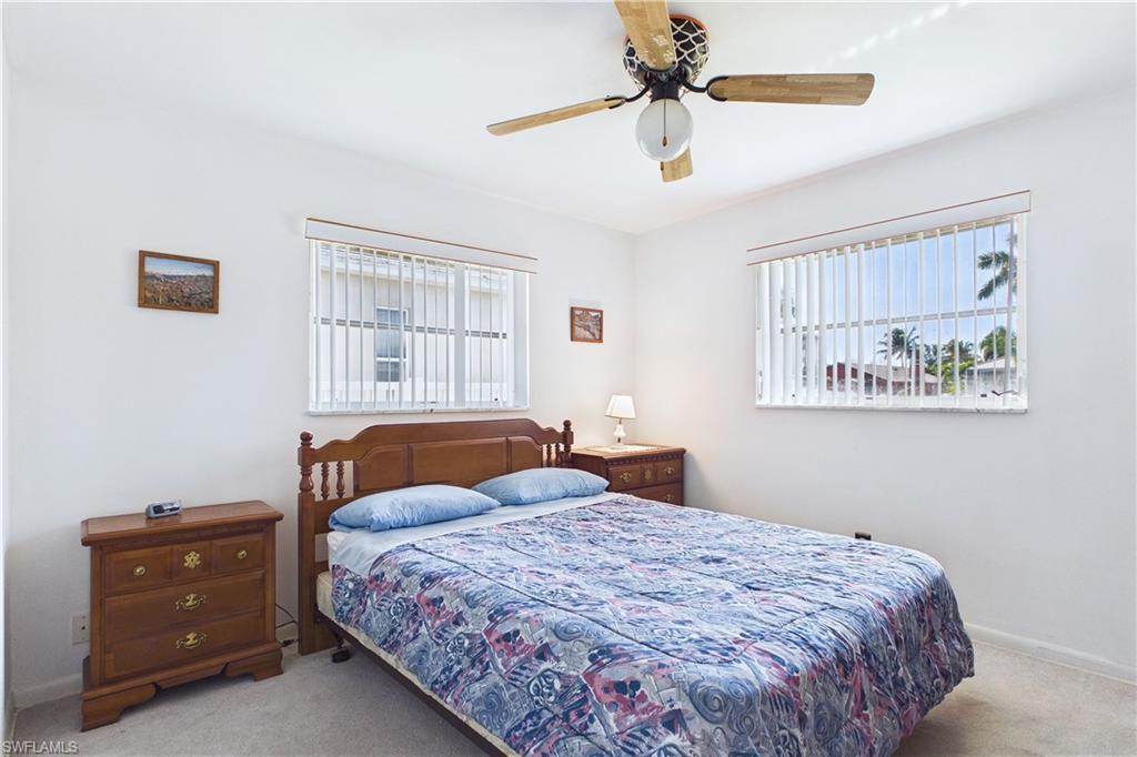 Carpeted bedroom featuring a ceiling fan and baseboards
