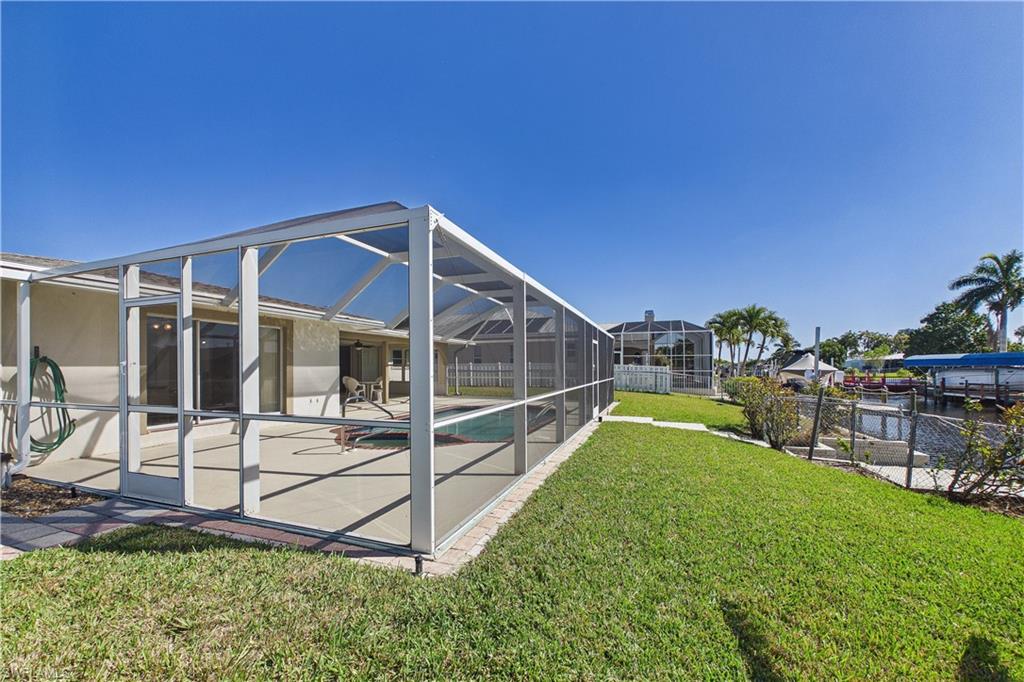 View of yard with a lanai, a sunroom, an outdoor pool, and a patio area