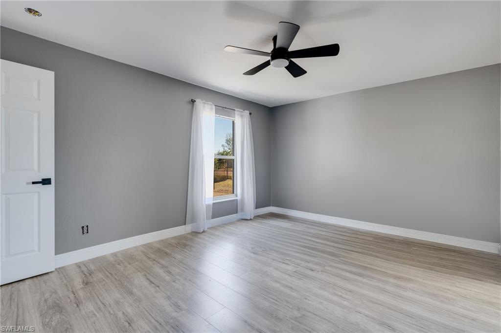 Unfurnished room with light wood finished floors and ceiling fan