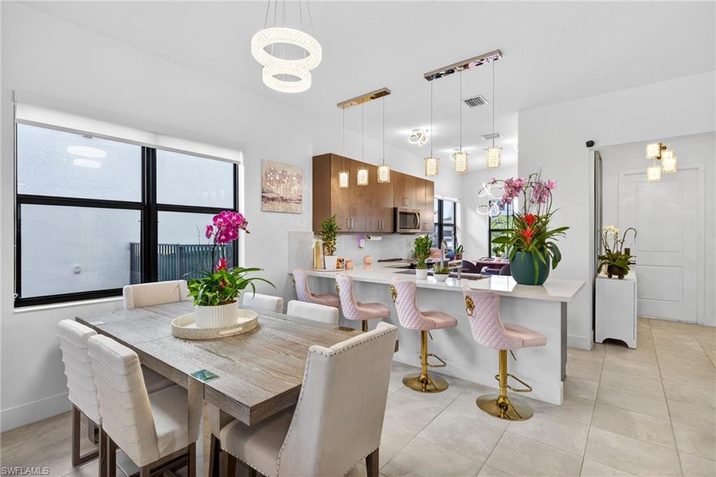 Dining area featuring track lighting and light tile patterned floors