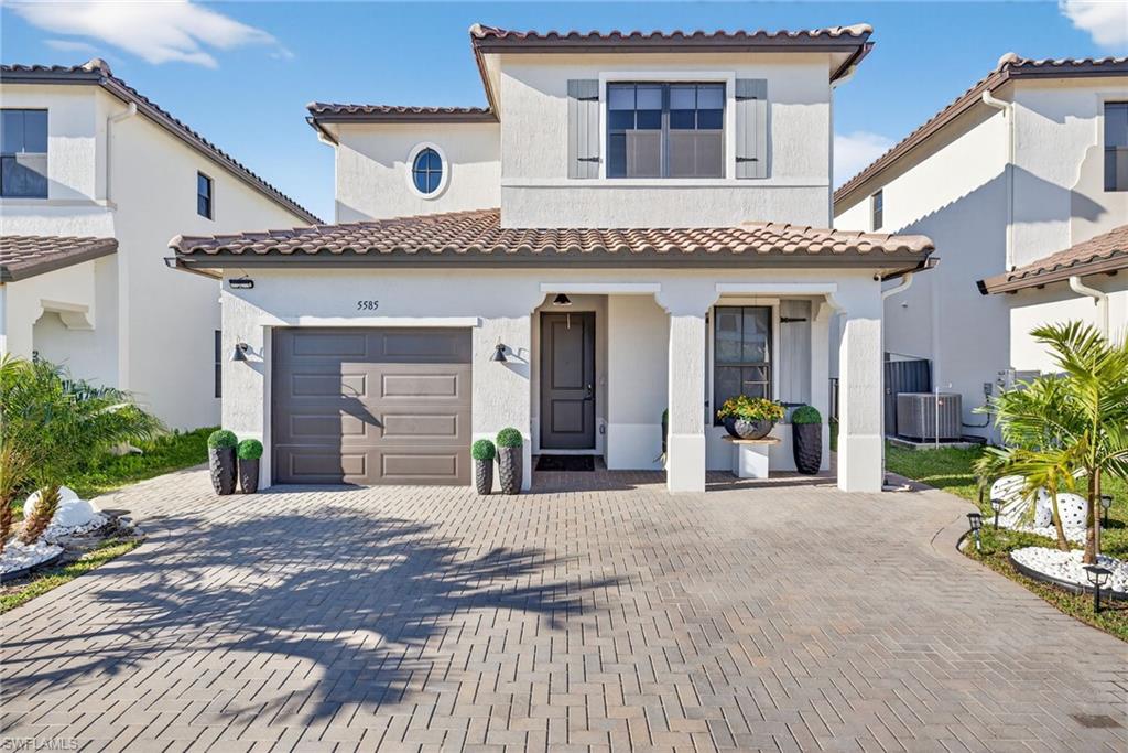 Mediterranean / spanish-style home featuring decorative driveway, stucco siding, a tile roof, and a garage