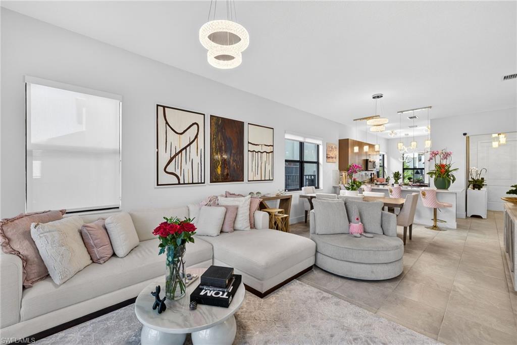 Living room featuring suspended lighting and light tile patterned flooring
