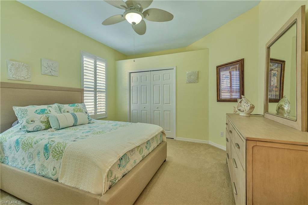 Bedroom with a ceiling fan, light colored carpet, and a closet