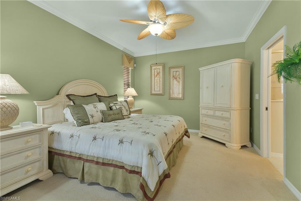 Bedroom featuring ornamental molding, light carpet, and a ceiling fan