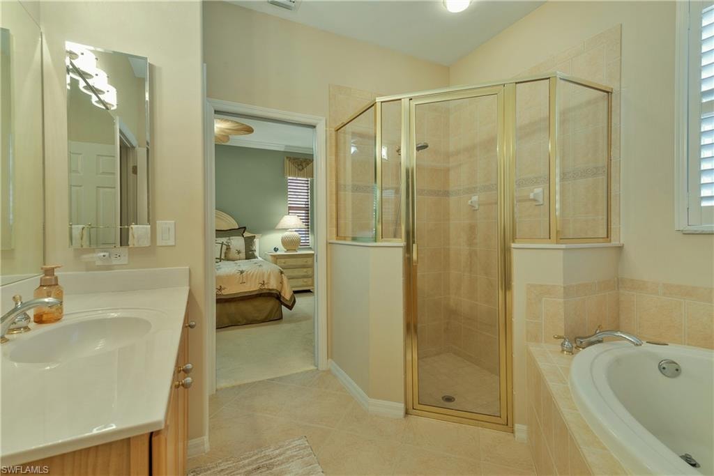 Ensuite bathroom with vanity, a stall shower, a garden tub, and light tile patterned flooring