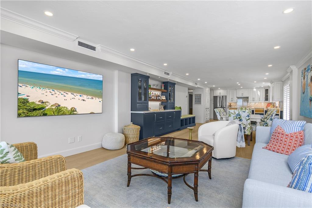Living area with light wood-type flooring, recessed lighting, and ornamental molding