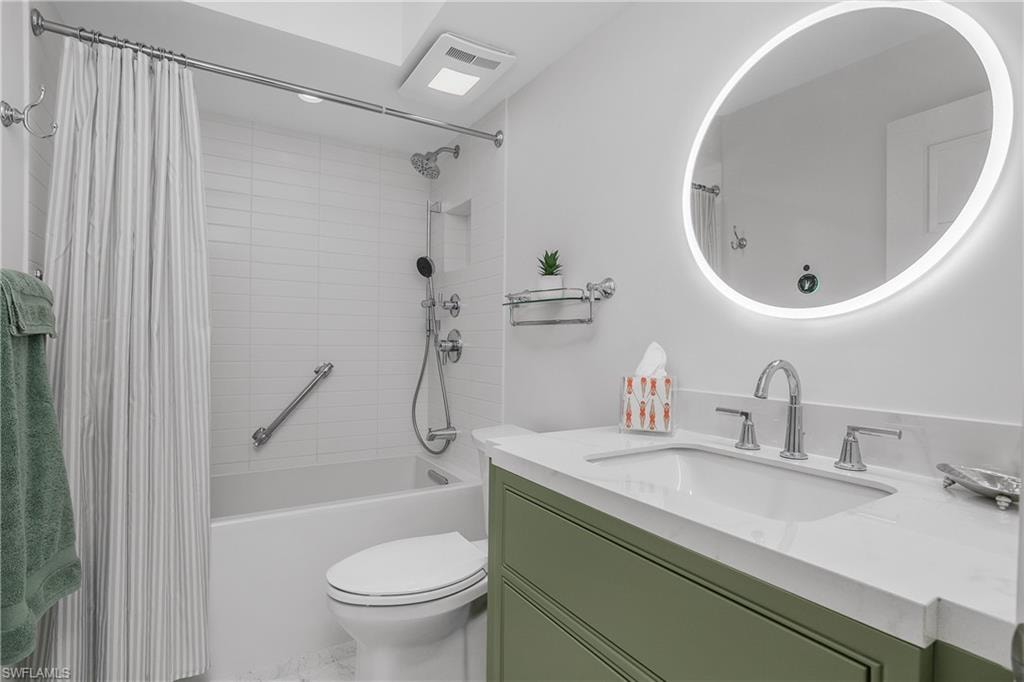 Custom tile and cabinetry in Full bath with vanity, shower/bathtub combination, and  lighted vanity mirror