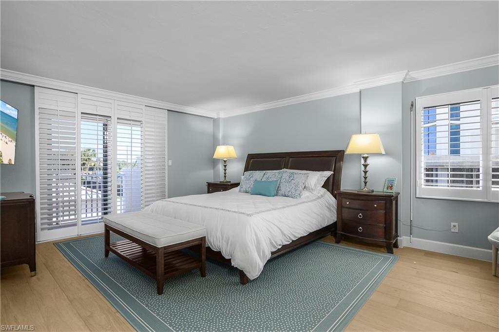 Main Bedroom with access to exterior balcony, light wood floors, and crown molding