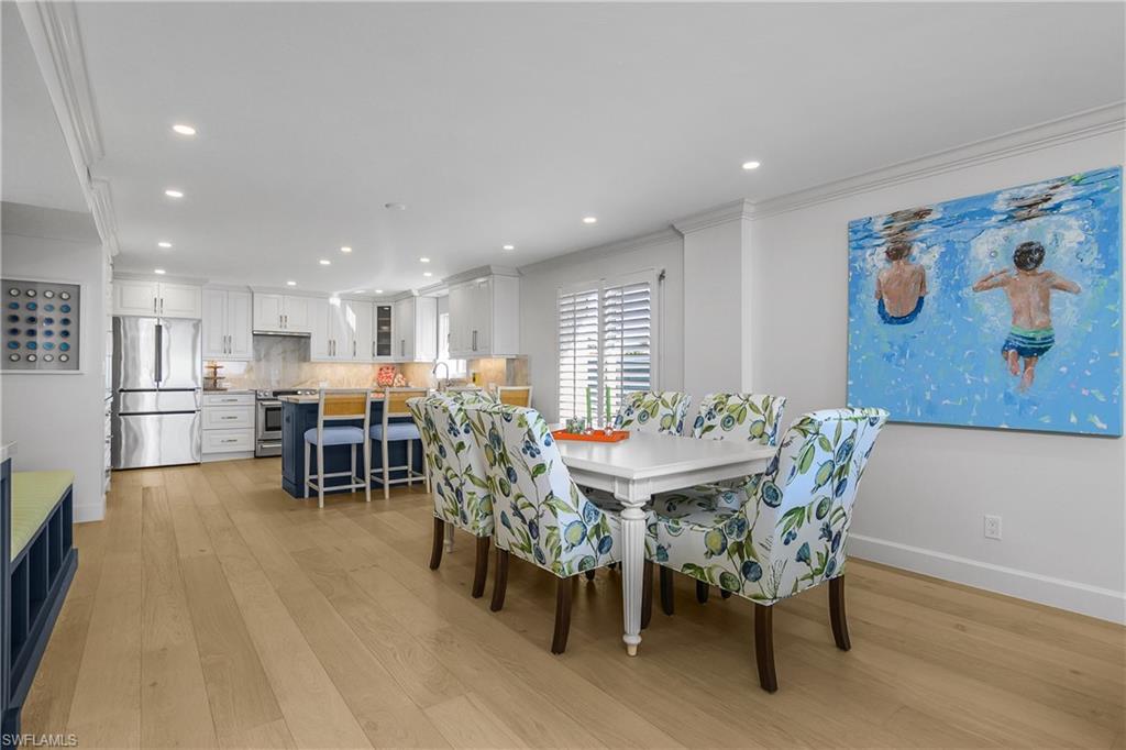 Dining space with Custom cabinetry and flooring, recessed lighting, and crown molding