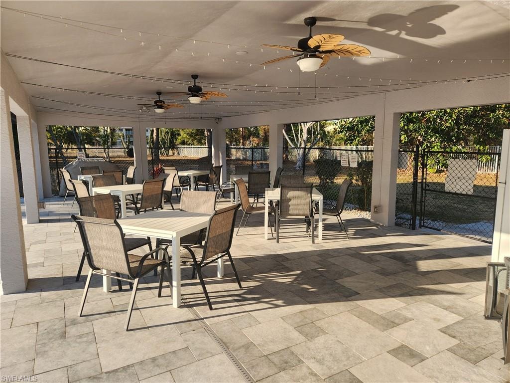 Sunroom with outdoor dining space, a patio area, and a ceiling fan