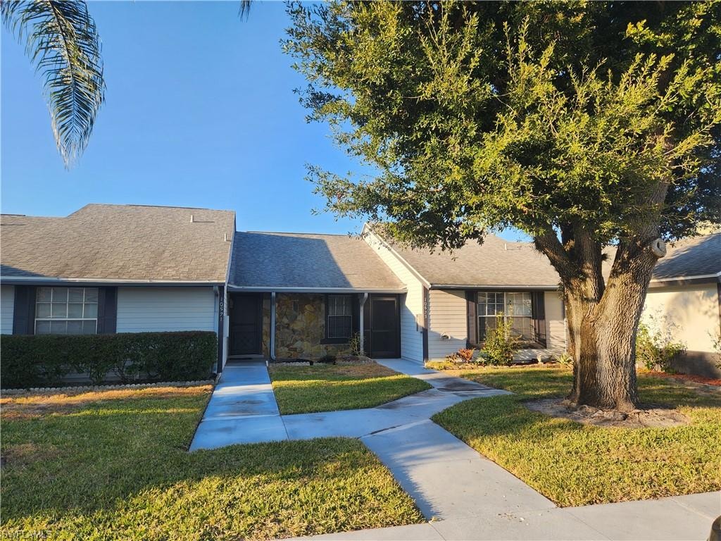 Single story home featuring a front lawn and stone siding