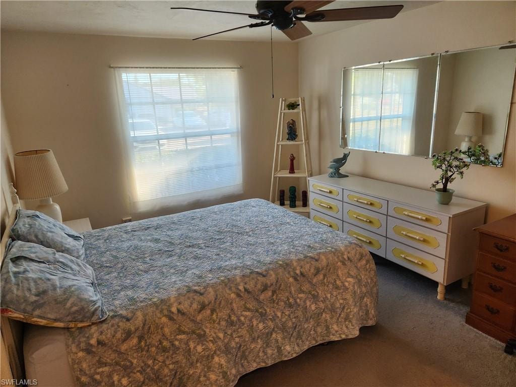 Bedroom featuring ceiling fan and dark carpet