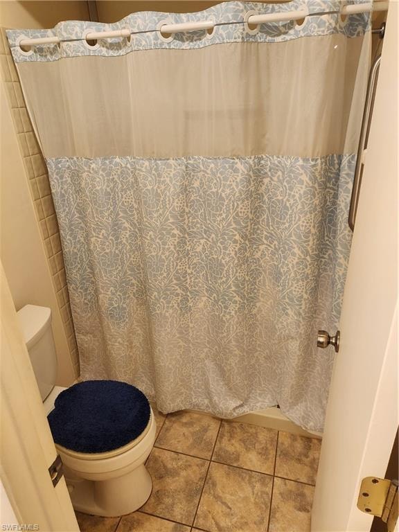 Bathroom featuring curtained shower and tile patterned flooring
