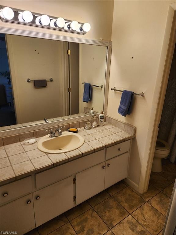 Bathroom featuring vanity and dark tile patterned floors