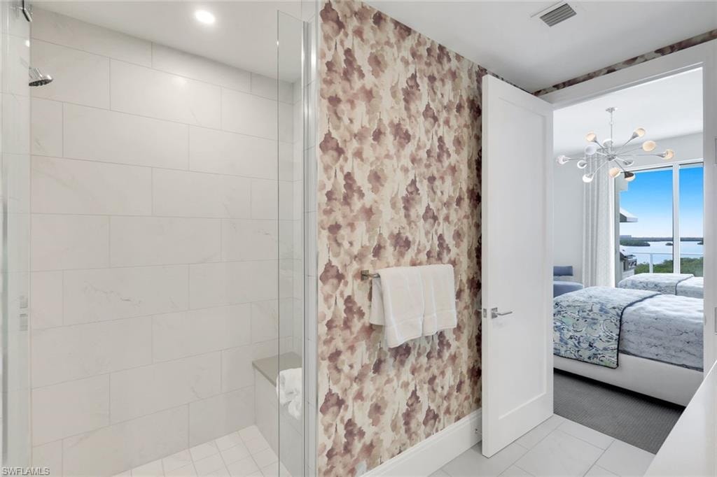 Statement wallpaper and a modern walk-in shower.