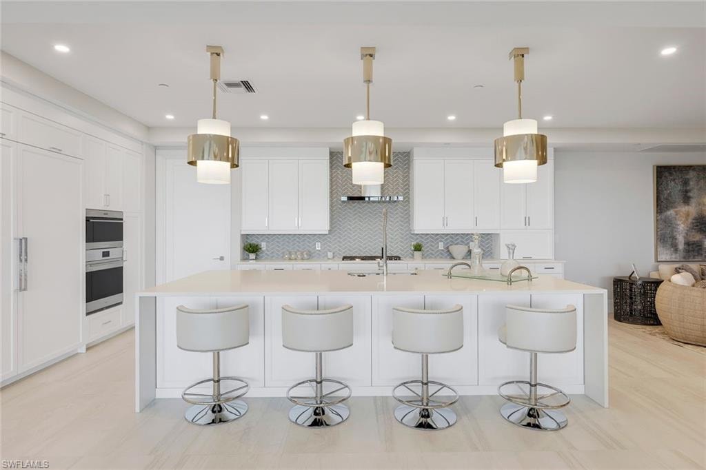 A striking kitchen featuring high-end appliances, a custom-designed backsplash, and abundant counter space for seamless functionality.