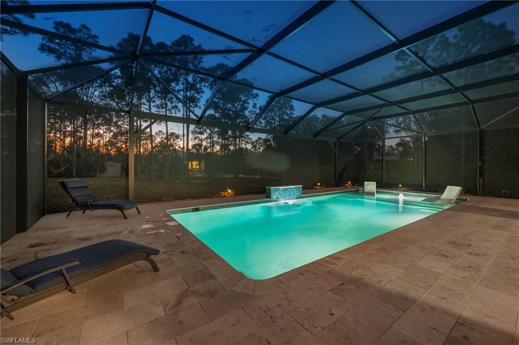Swimming pool featuring a patio area, a sunroom, and a lanai