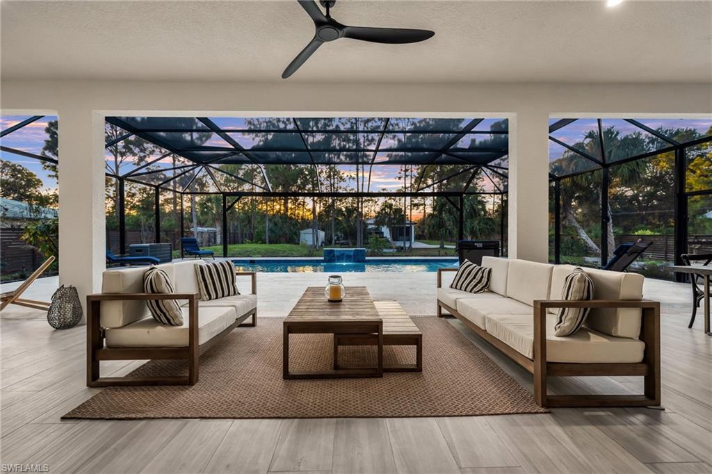 Patio terrace at dusk featuring a patio area, a sunroom, an outdoor pool, an outdoor hangout area, and glass enclosure