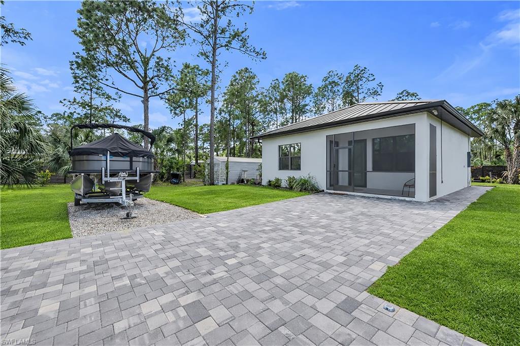 Rear view of property with a standing seam roof and stucco siding