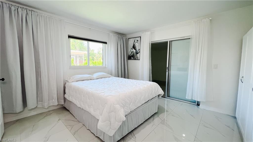Bedroom featuring light marble finish floors and a closet