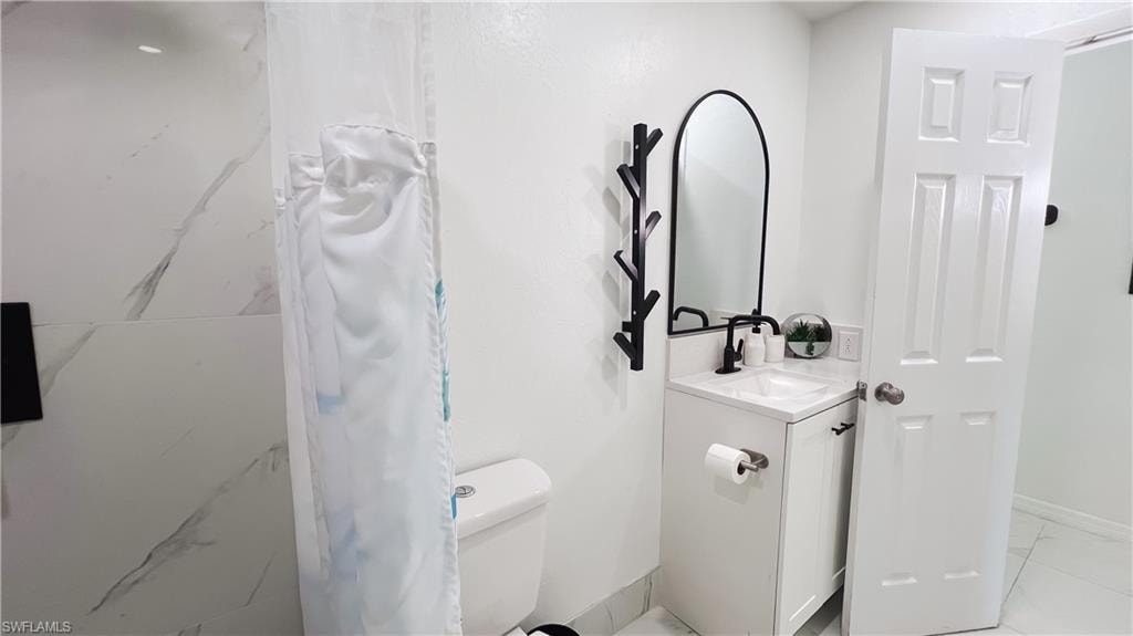 Full bath featuring curtained shower and vanity