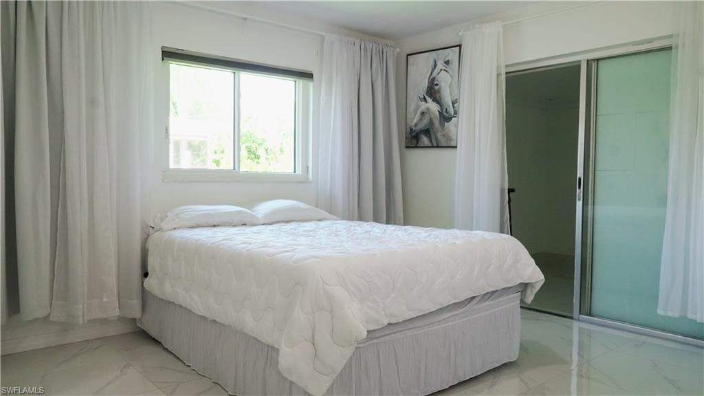 Bedroom featuring a closet and marble look tiles