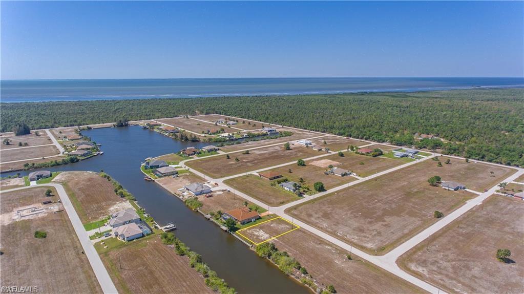 Drone / aerial view of a heavily wooded area and a nearby body of water