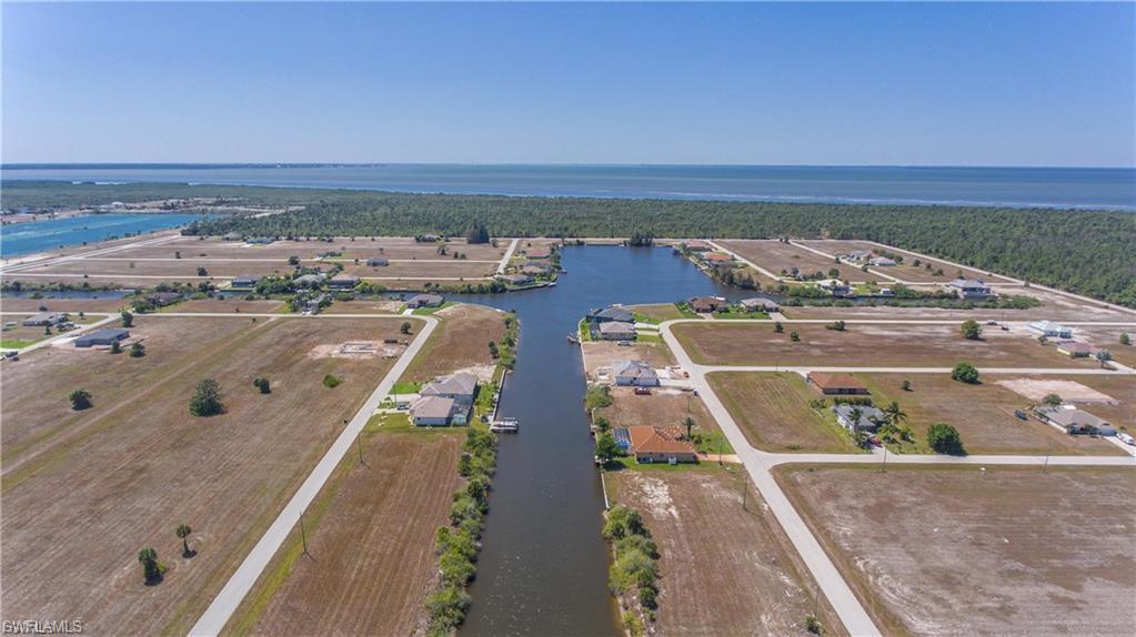 Aerial view of property's location featuring a large body of water and a forest