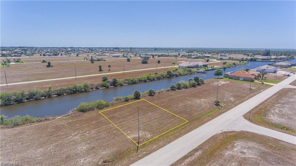 Aerial view of property and surrounding area featuring a large body of water and property parcel outlined