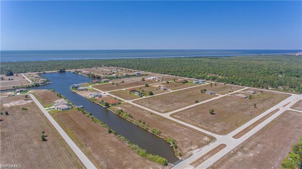 Drone / aerial view of a nearby body of water and a forest