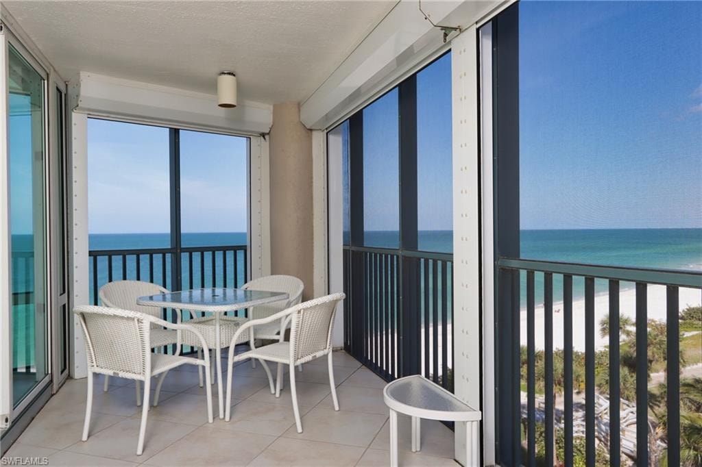 Sunroom with view of water and beach