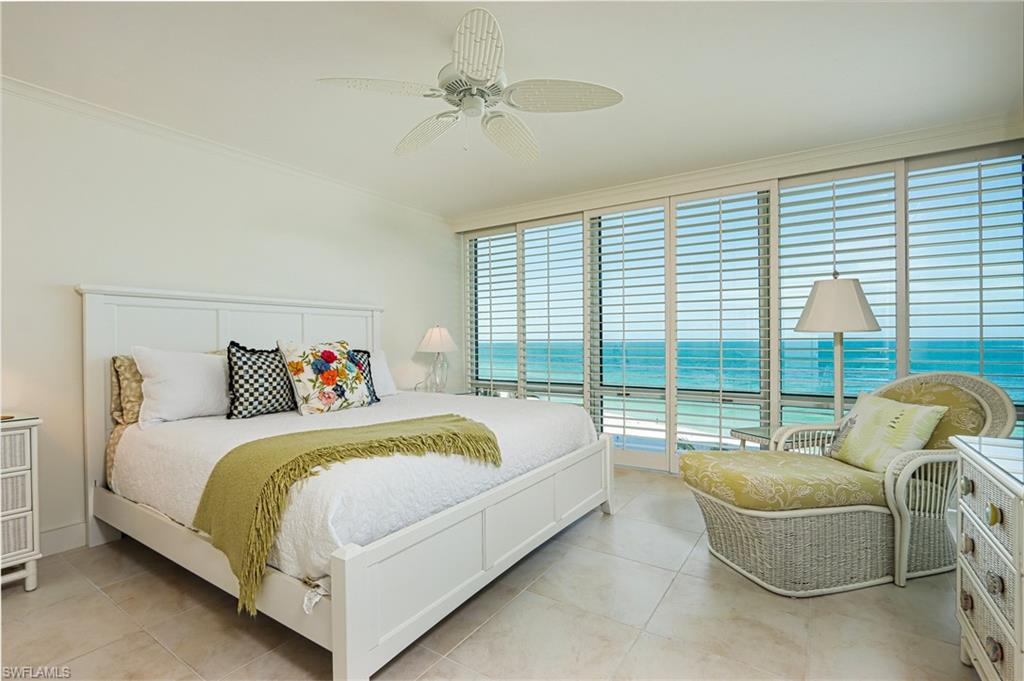 Bedroom with ornamental molding, ceiling fan, a water view, and light tile patterned floors