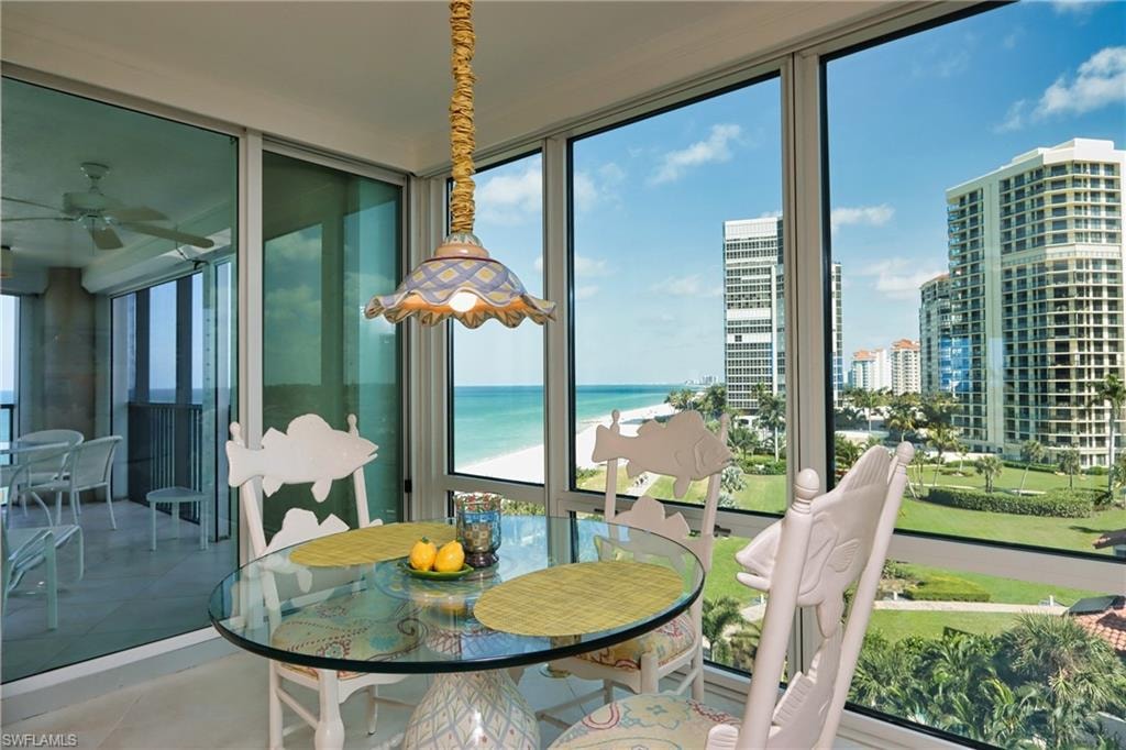 Sunroom / solarium featuring a water view and a city view