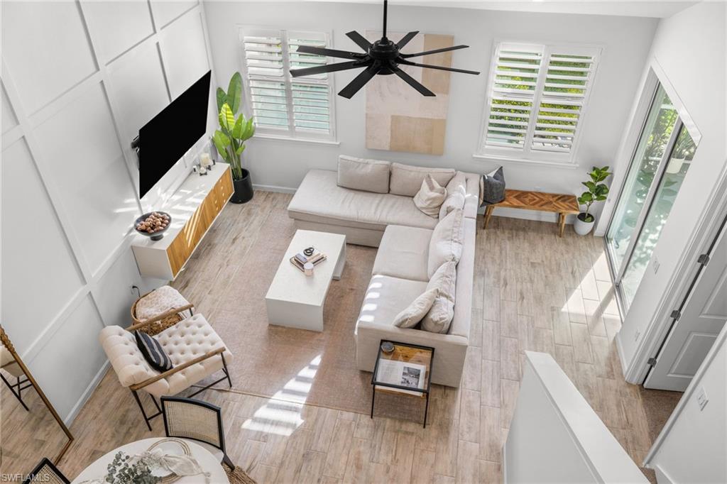 Living area with light wood-style floors and a ceiling fan