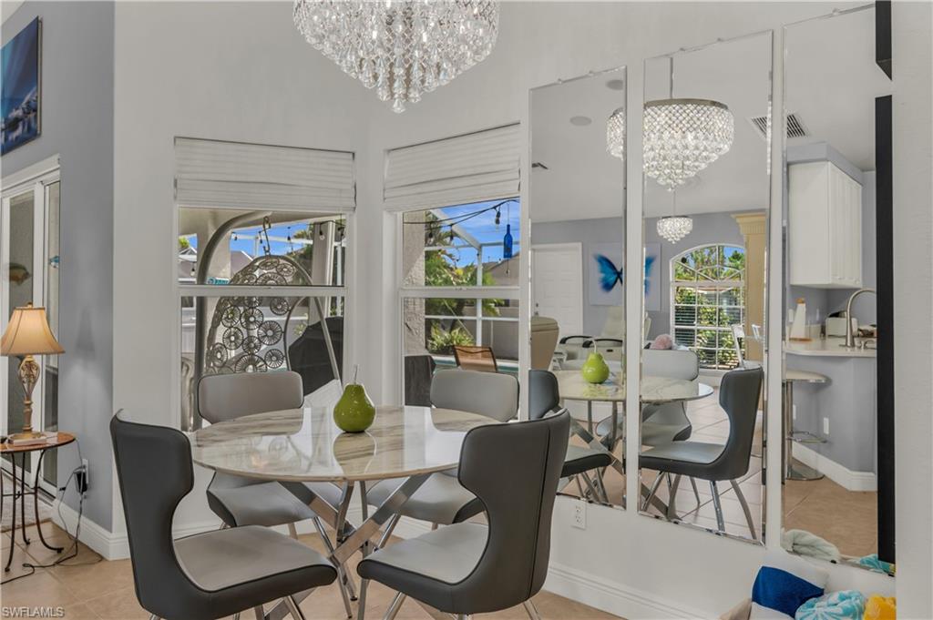 Dining space featuring hanging lights, light tile patterned floors, and a high ceiling
