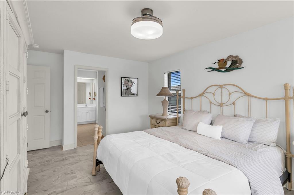 Bedroom with connected bathroom and baseboards