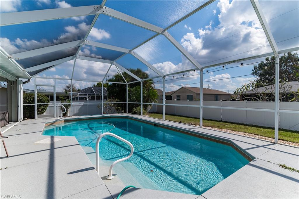 View of pool with a fenced backyard, glass enclosure, and a sunroom