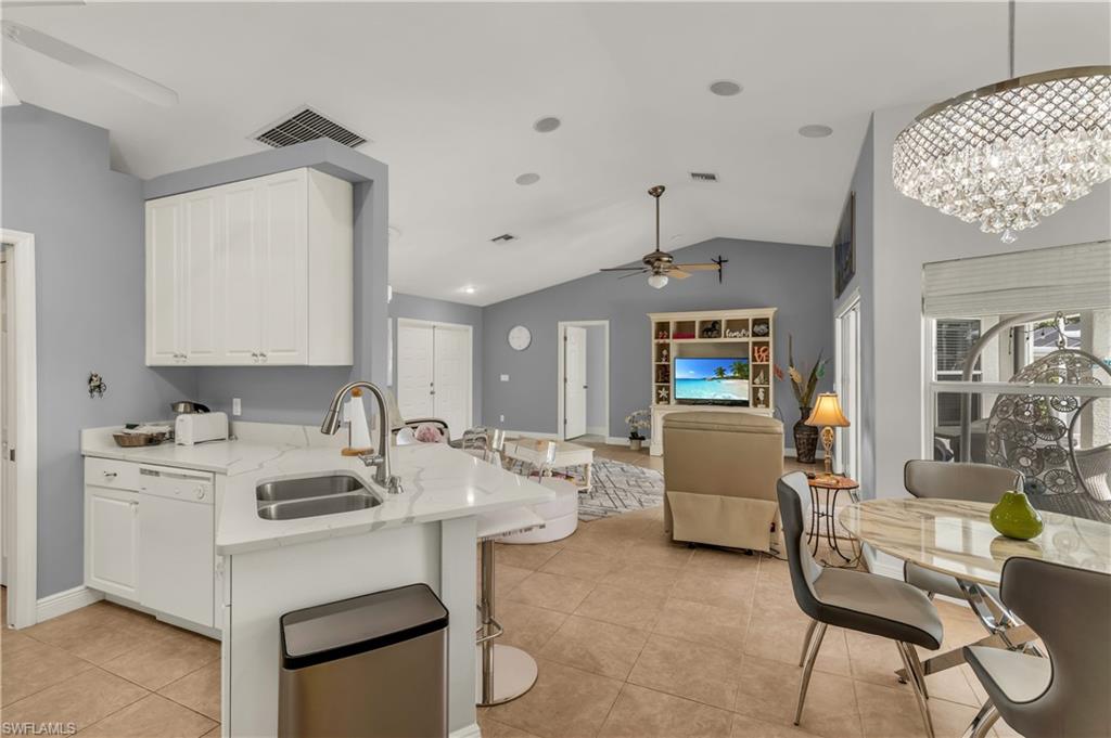 Kitchen featuring ceiling fan, white cabinets, dishwasher, a peninsula, and open floor plan