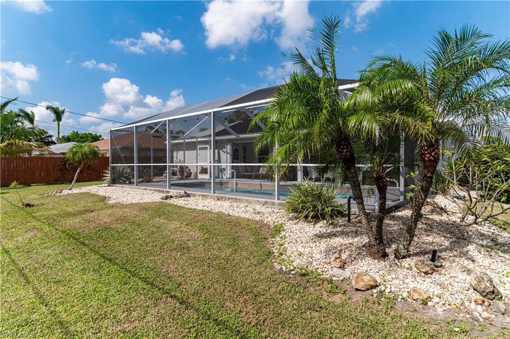 Rear view of house featuring a lanai, an outdoor pool, a sunroom, and a patio
