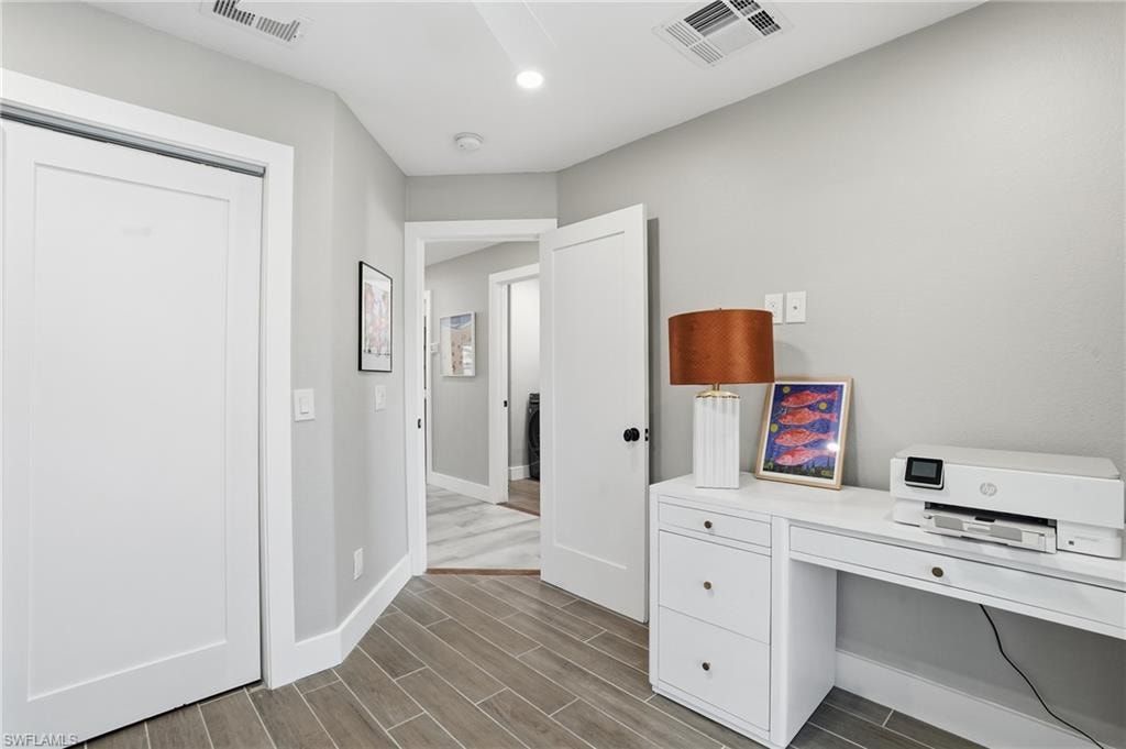 Unfurnished office with wood finish floors and baseboards - Virtually Edited Image